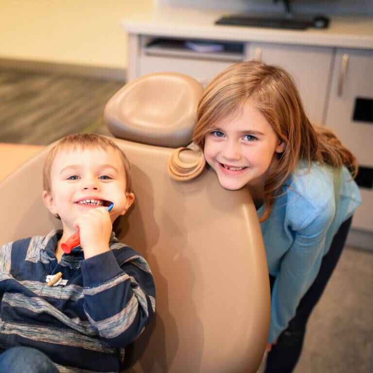 Sister and brother smiling at the dentist office